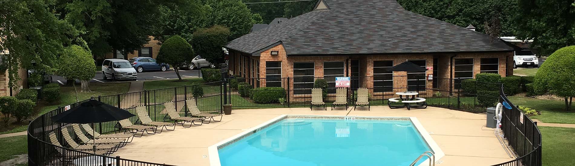 Pool with lounge chairs and apt buildings Longview, Texas Apartments For Rent l Saddle Book
